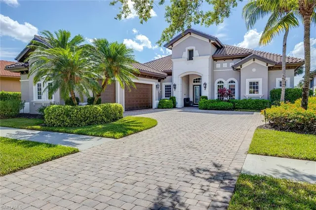 a front view of a house with a yard and potted plants