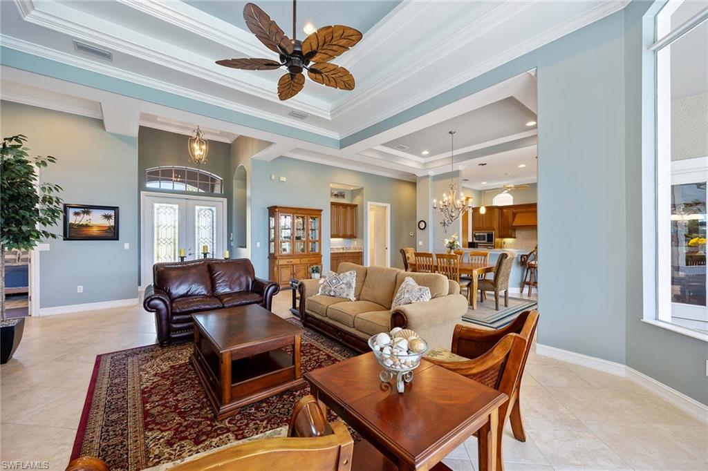 8902 Shenendoah Circle Naples, FL 34113 - Photo 8 of 28 a living room with furniture a chandelier and a window