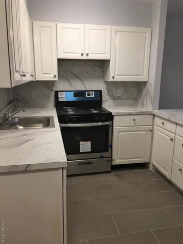 a kitchen with granite countertop white cabinets and sink