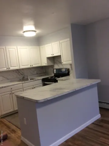 a kitchen with stainless steel appliances granite countertop a sink a stove a refrigerator a center island and cabinets