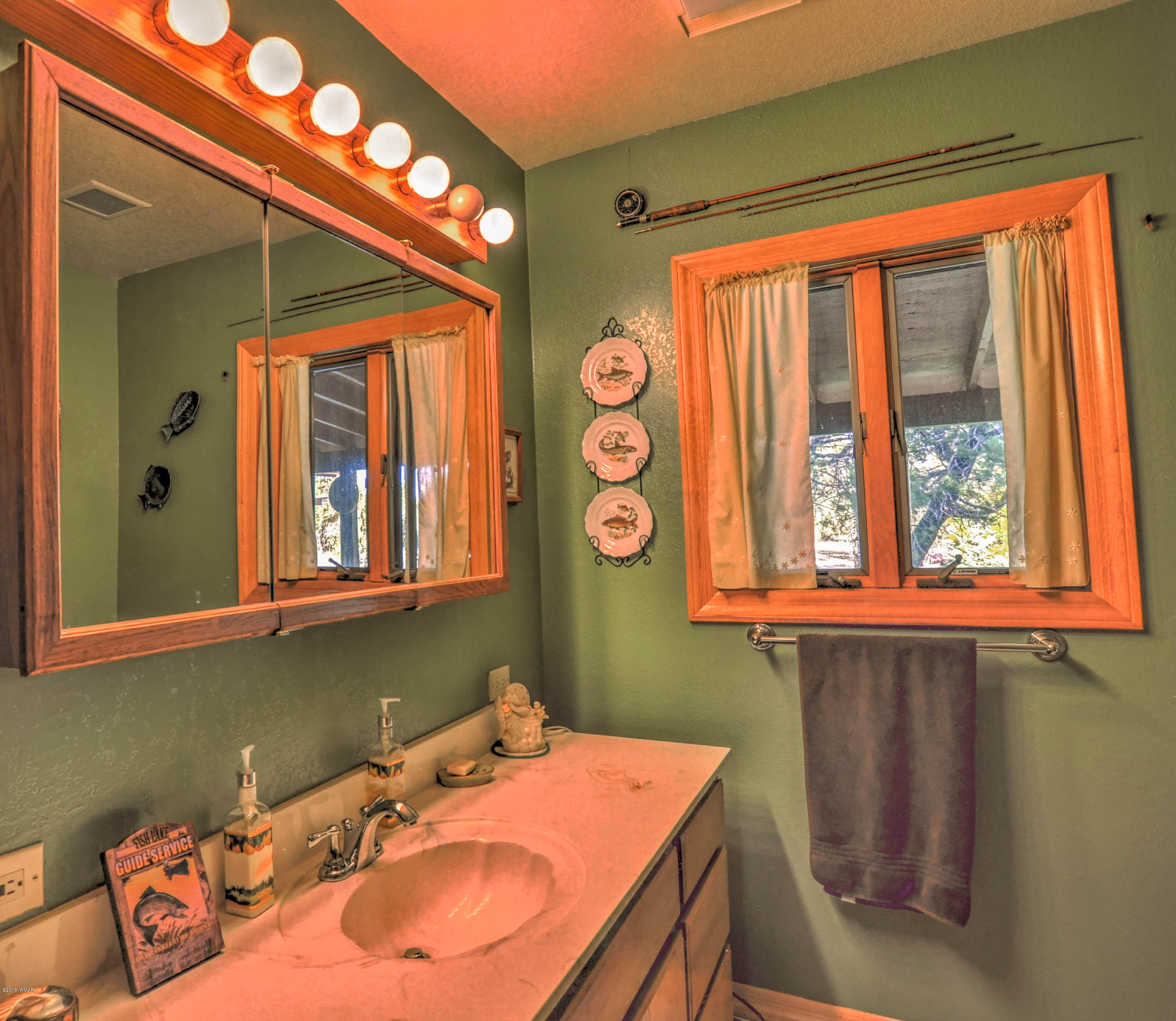 2151 Chevelon Road Overgaard, AZ 85933 - Photo 8 of 27 a bathroom with a sink a mirror and a window