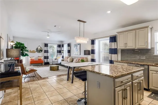 a open kitchen with stainless steel appliances granite countertop a refrigerator and a stove top oven