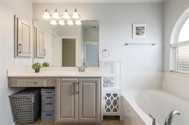 a bathroom with a sink a large mirror and a bathtub