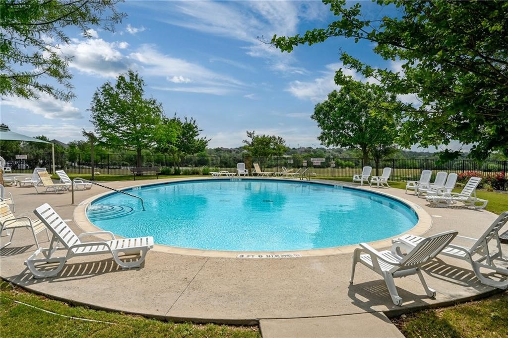 1908 Golden Arrow Avenue Cedar Park, TX 78613 - Photo 27 of 31 a view of a swimming pool with lawn chairs under an umbrella