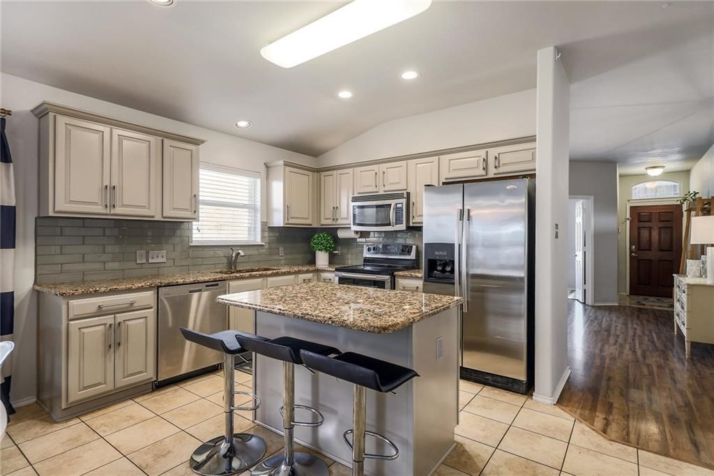 1908 Golden Arrow Avenue Cedar Park, TX 78613 - Photo 3 of 31 a kitchen with stainless steel appliances granite countertop a refrigerator and stove