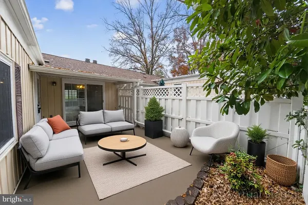 a view of a patio with couches table and chairs and potted plants