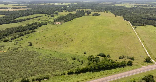 a view of a field with trees in the background