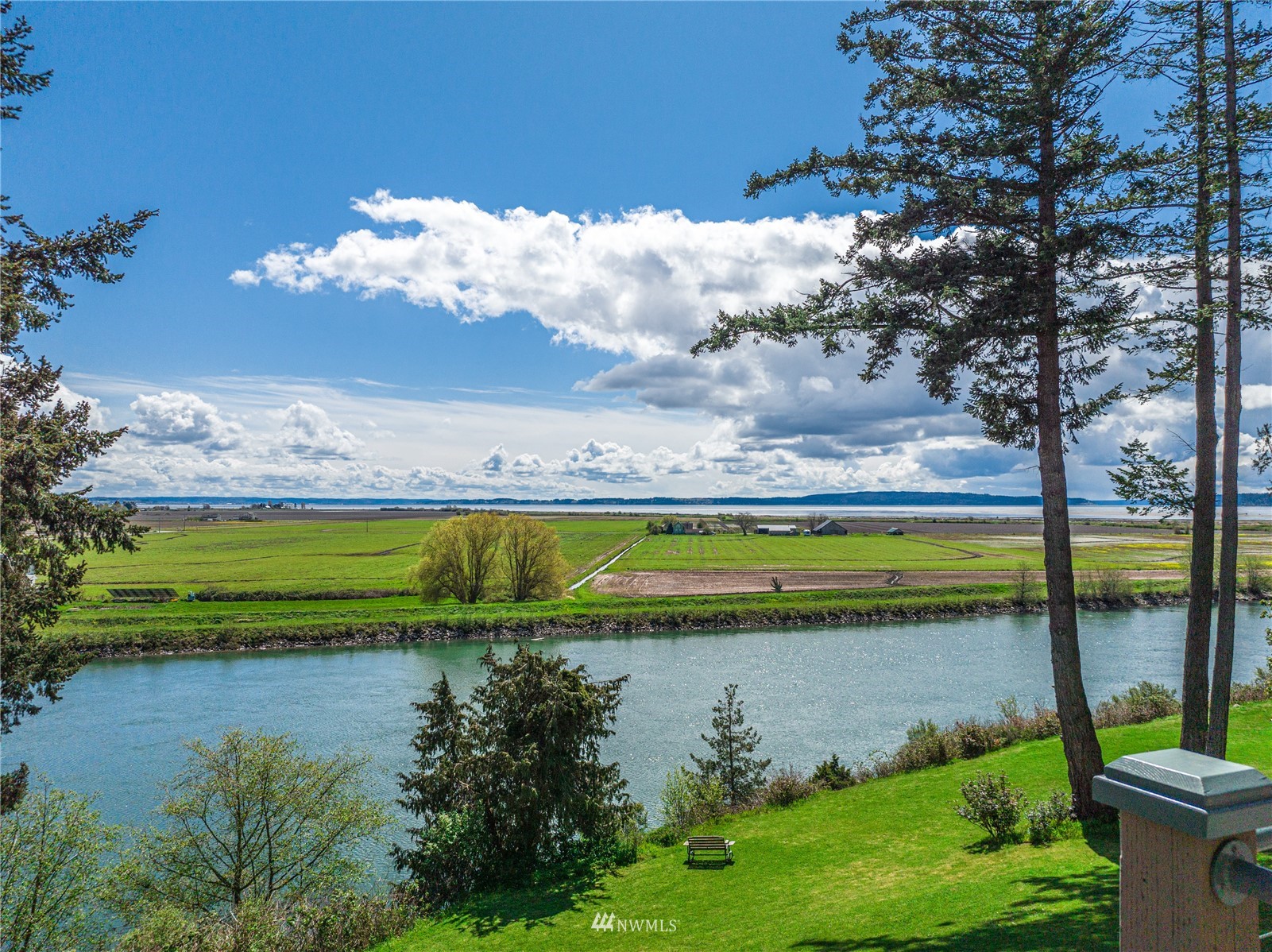 19695 Landing Road Mount Vernon, WA 98273 - Photo 3 of 40 a view of a lake with lawn chairs and large trees