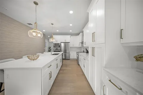 a large white kitchen with a sink and dishwasher