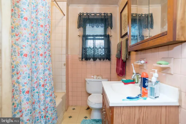 a bathroom with a sink toilet and shower curtain