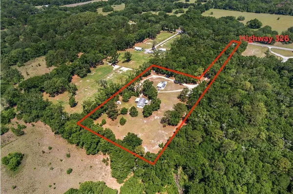 an aerial view of a house with a yard and trees