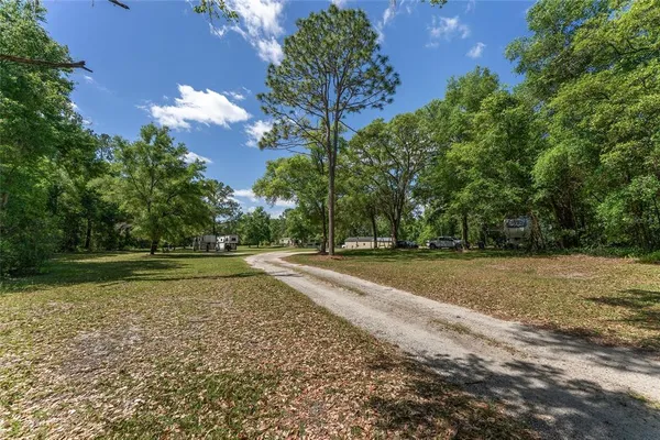 a big yard with lots of green space and trees around