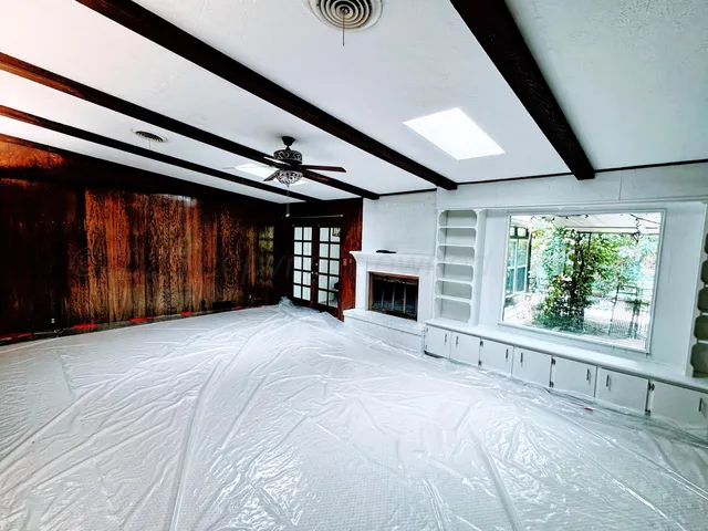 a view of an empty room with a fireplace and a window