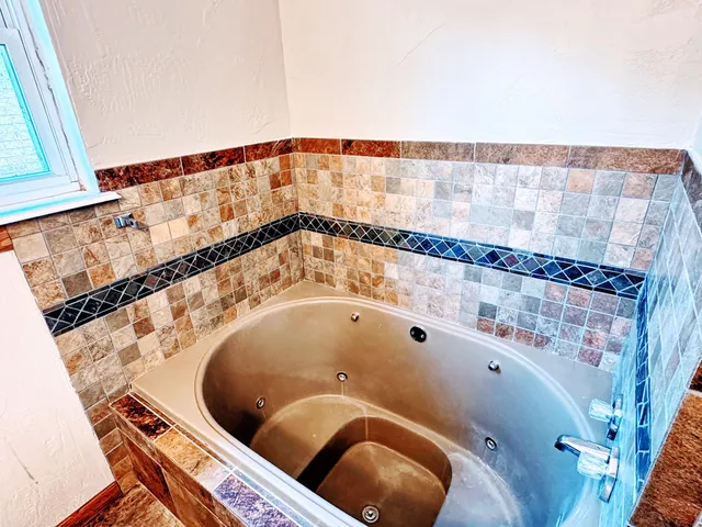 a large white tub sitting in a bathroom