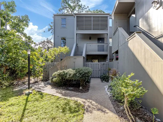 a backyard of a house with chairs and wooden fence