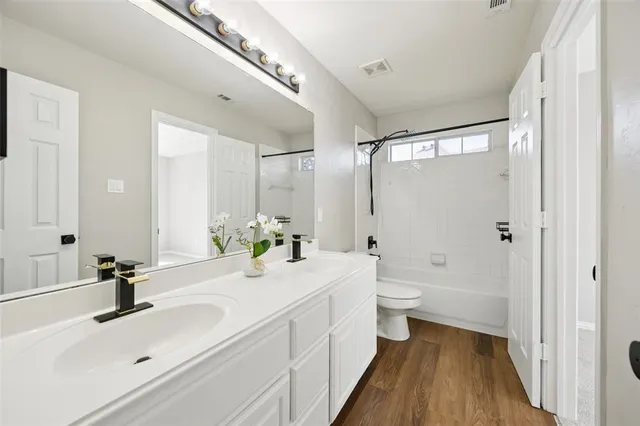 a view of an empty room with wooden floor fireplace and a window