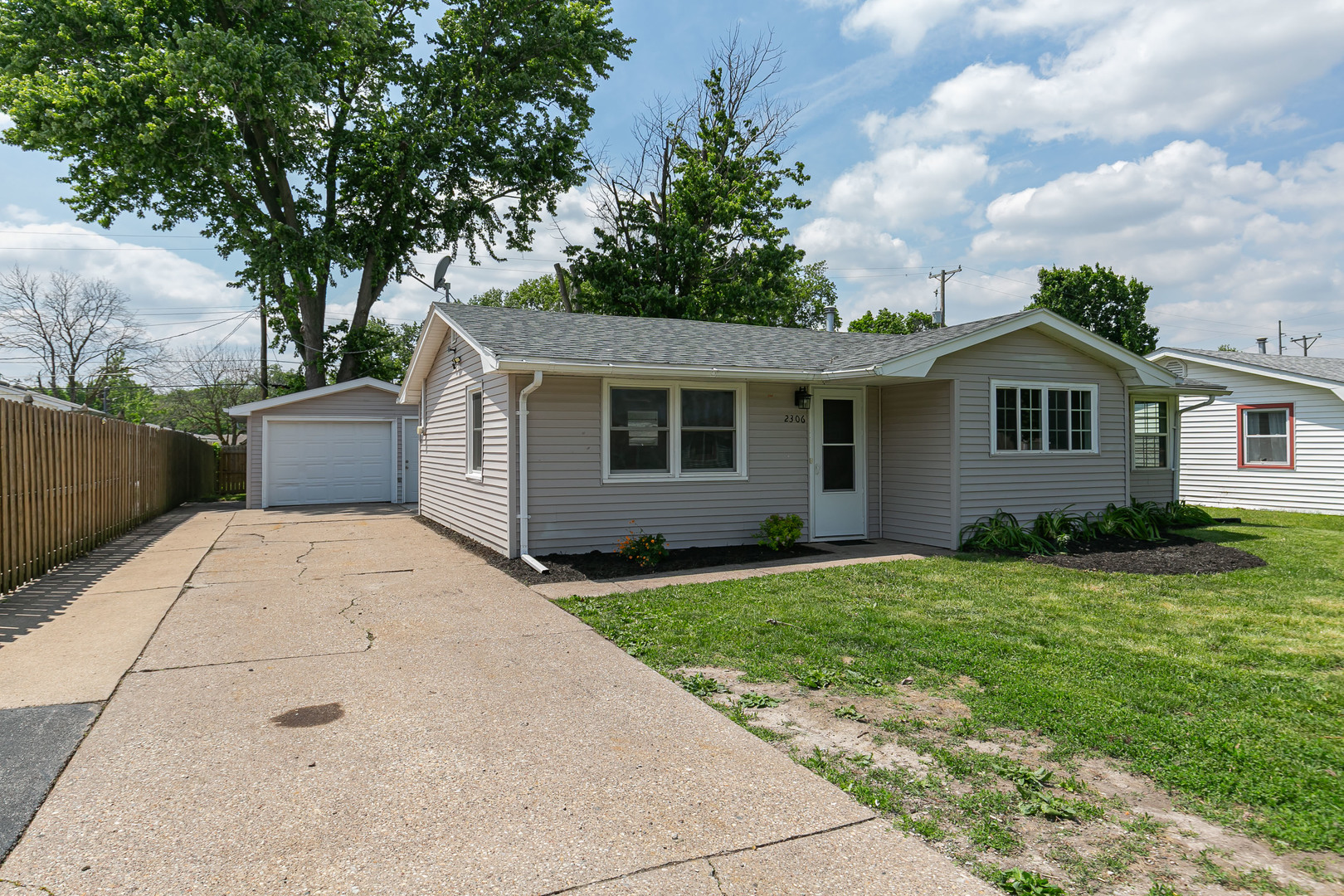 2306 9th Street Silvis, IL 61282 - Photo 2 of 32 a view of a yard in front of a house with plants and large tree