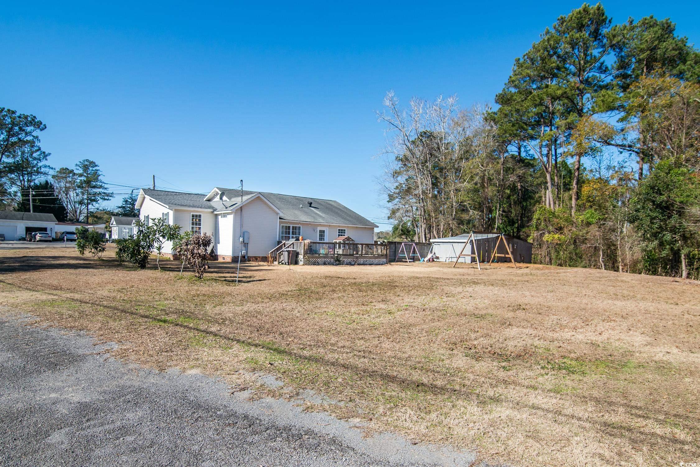 616 County Rd S-22-452 Georgetown, SC 29440 - Photo 5 of 33 View of yard with a wooden deck and an outdoor str