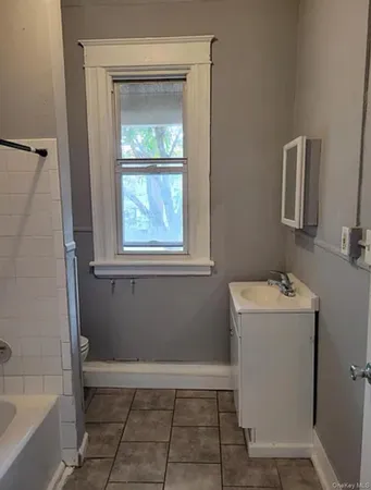 a bathroom with a sink a window and a mirror