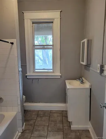 a bathroom with a sink a window and a mirror