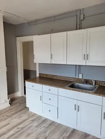 a kitchen with granite countertop white cabinets and sink