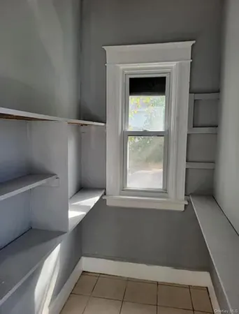 a view of a small space with wooden racks and a window