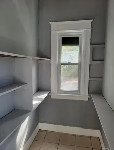 a view of a small space with wooden racks and a window