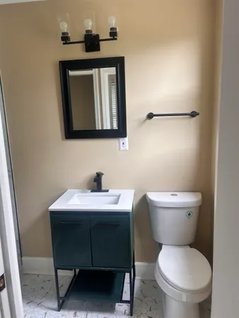 a bathroom with a toilet a sink and mirror