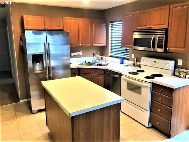 983 Southwest Junction Place Gresham, OR 97080 - Photo 2 of 10 a kitchen with a sink stove and refrigerator