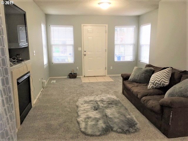 983 Southwest Junction Place Gresham, OR 97080 - Photo 3 of 10 a living room with furniture a flat screen tv and a fireplace