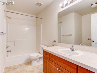 983 Southwest Junction Place Gresham, OR 97080 - Photo 6 of 10 a bathroom with a sink a toilet and a large mirror