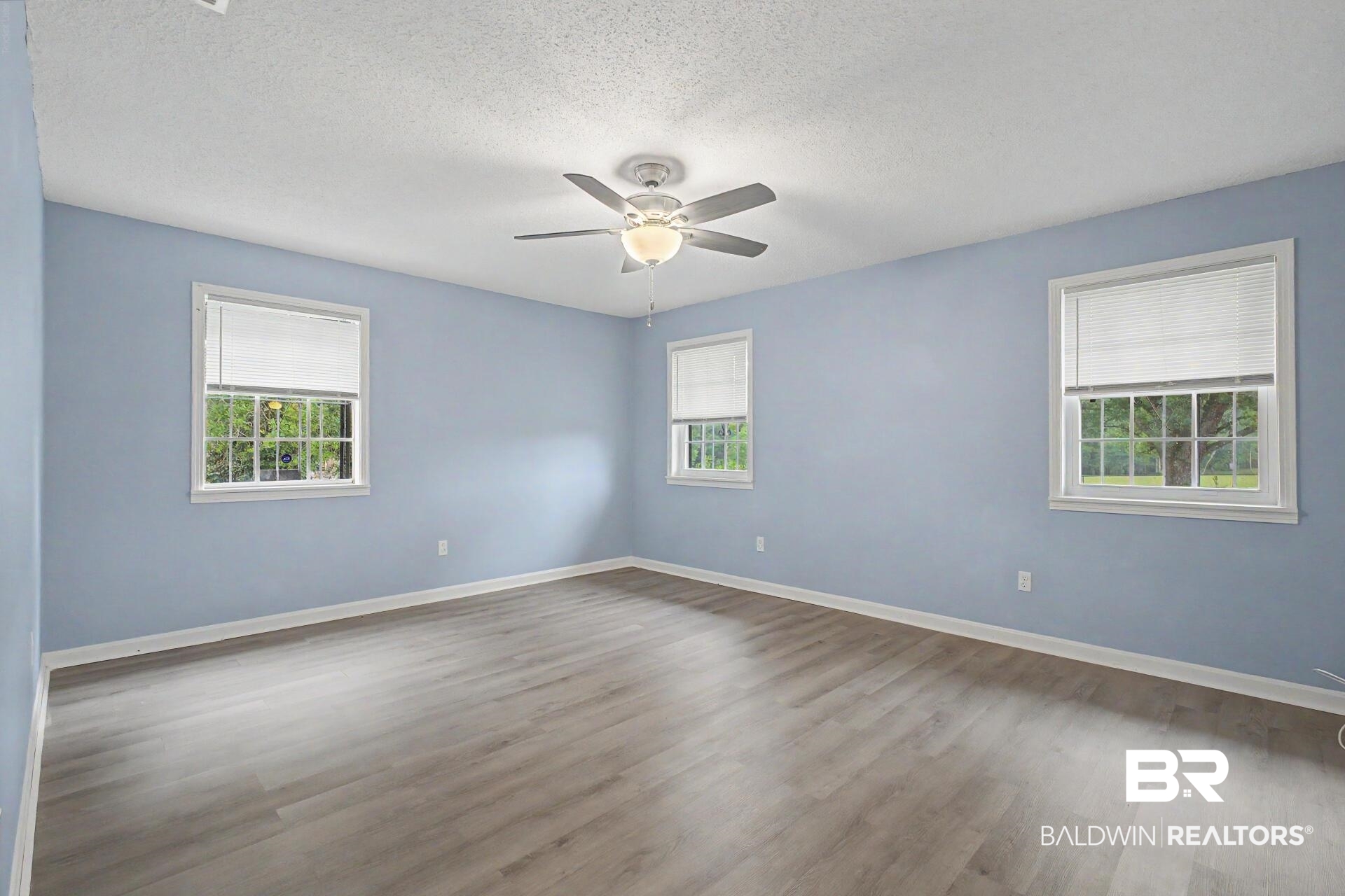 3791 Robinsonville Road Atmore, AL 36502 - Photo 43 of 47 Spacious interior room featuring wood-finish flooring, light blue walls, and a ceiling fan with integrated lighting