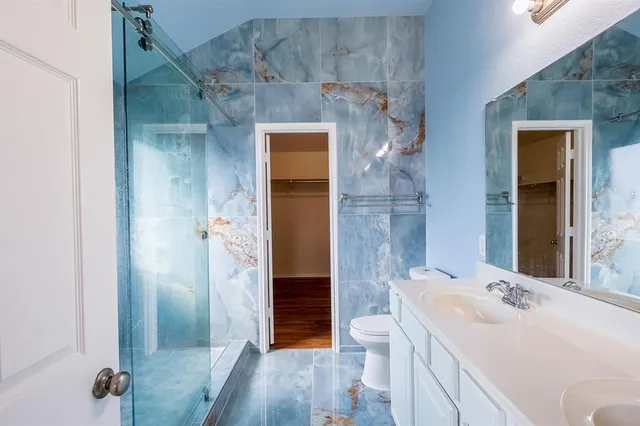 a bathroom with a sink a toilet and shower