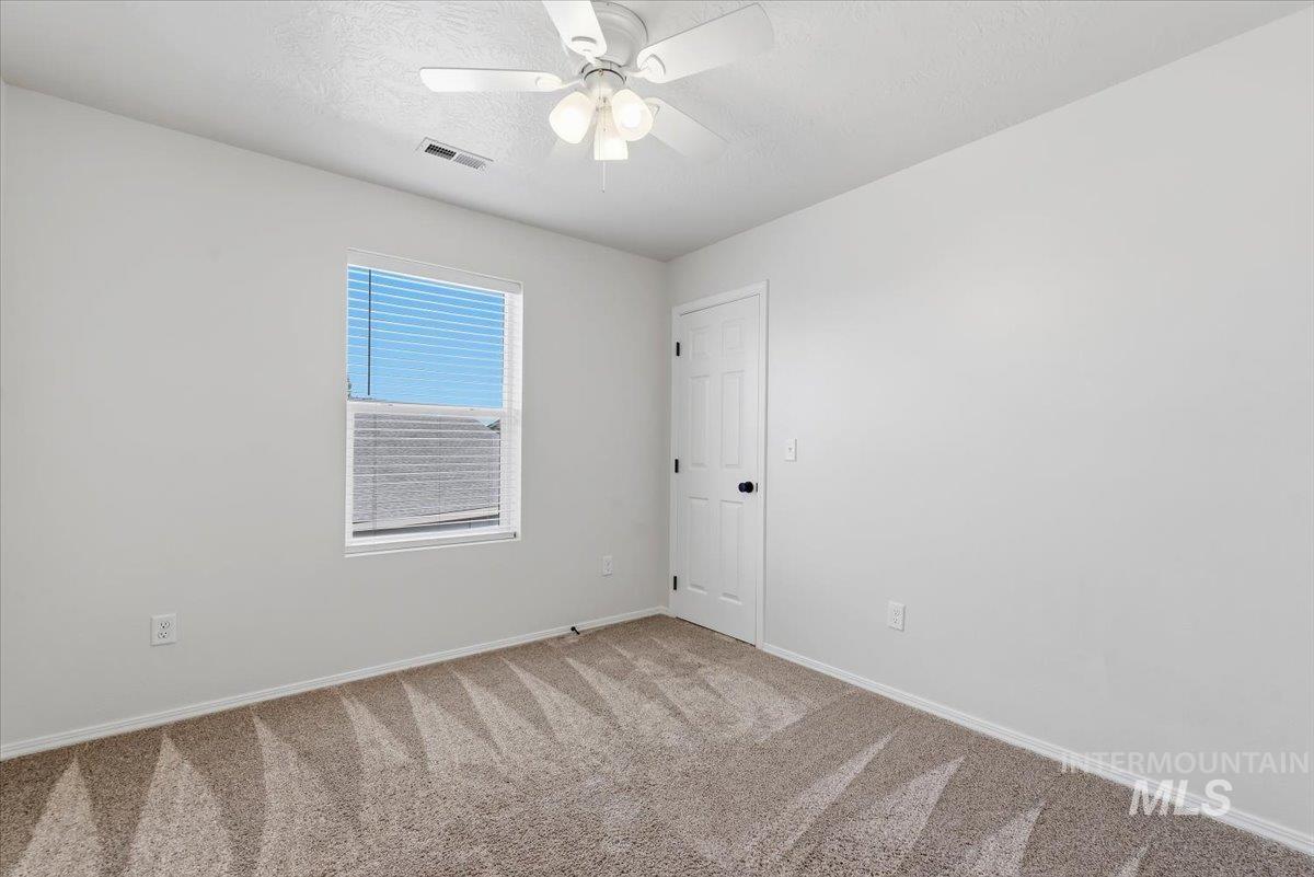 12310 West Hidden Point Drive Star, ID 83669 - Photo 19 of 48 Room featuring neutral tone carpet, white walls, and natural light