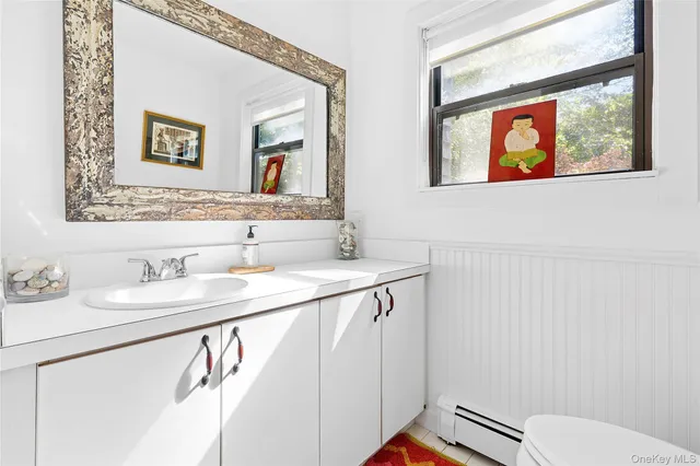 a bathroom with a toilet a sink and mirror