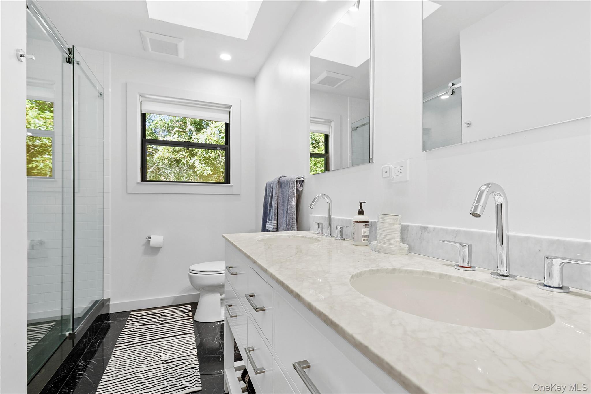 98 Hands Creek Road East Hampton, NY 11937 - Photo 16 of 20 Bathroom featuring a shower stall, double vanity, a skylight, and recessed lighting