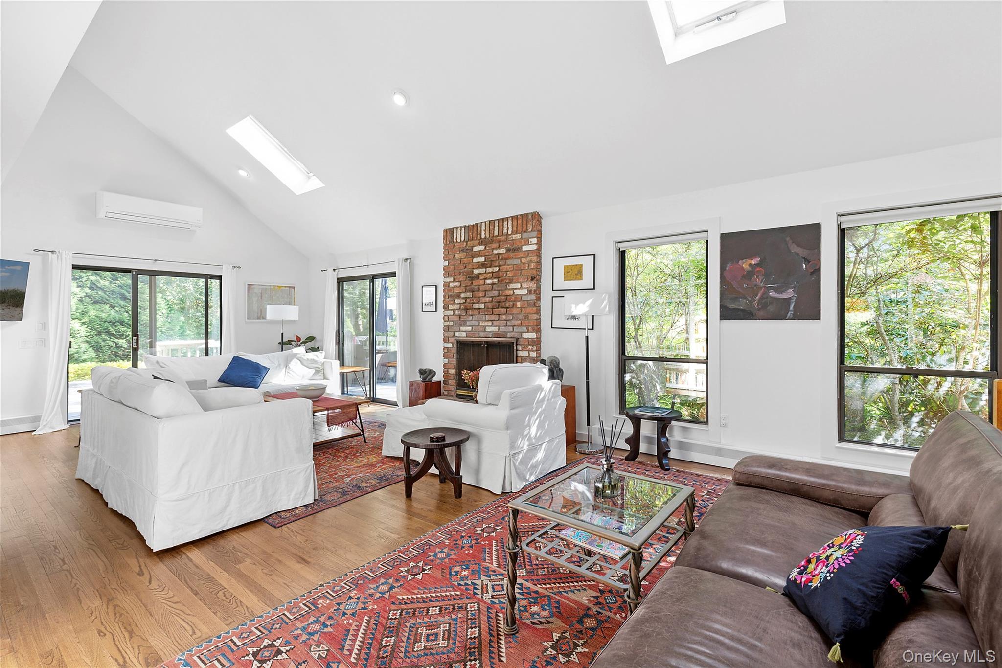 98 Hands Creek Road East Hampton, NY 11937 - Photo 5 of 20 Living area with high vaulted ceiling, a skylight, light wood-style flooring, a wall mounted AC, and recessed lighting