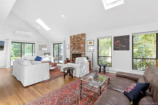 a living room with furniture floor to ceiling window and wooden floor