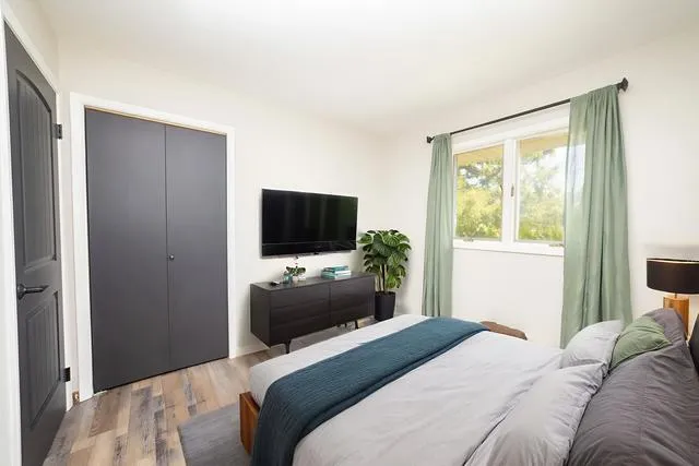 a bedroom with a bed and a flat screen tv