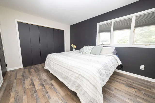 a bedroom with a bed and a large window