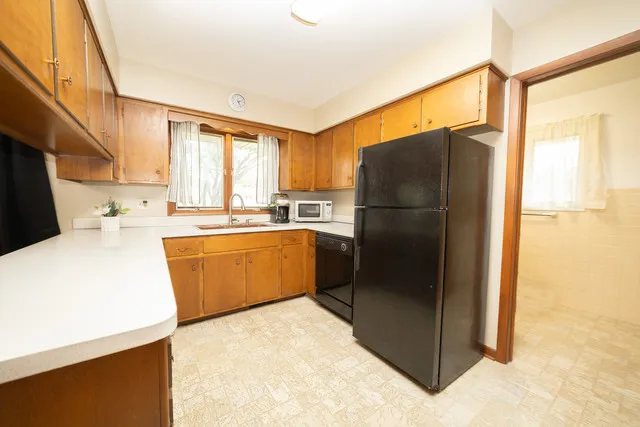 a view of a kitchen with a stove fridge and wooden floor