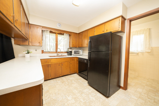712 Homestead Place Joliet, IL 60435 - Photo 21 of 26 a kitchen with a refrigerator a sink and cabinets