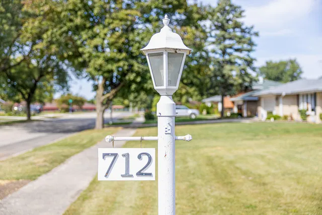 a view of a house with a yard and large tree