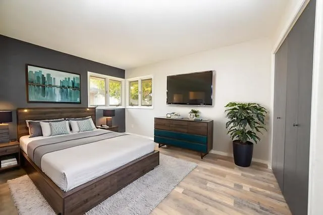 a bedroom with a bed potted plant and a flat screen tv
