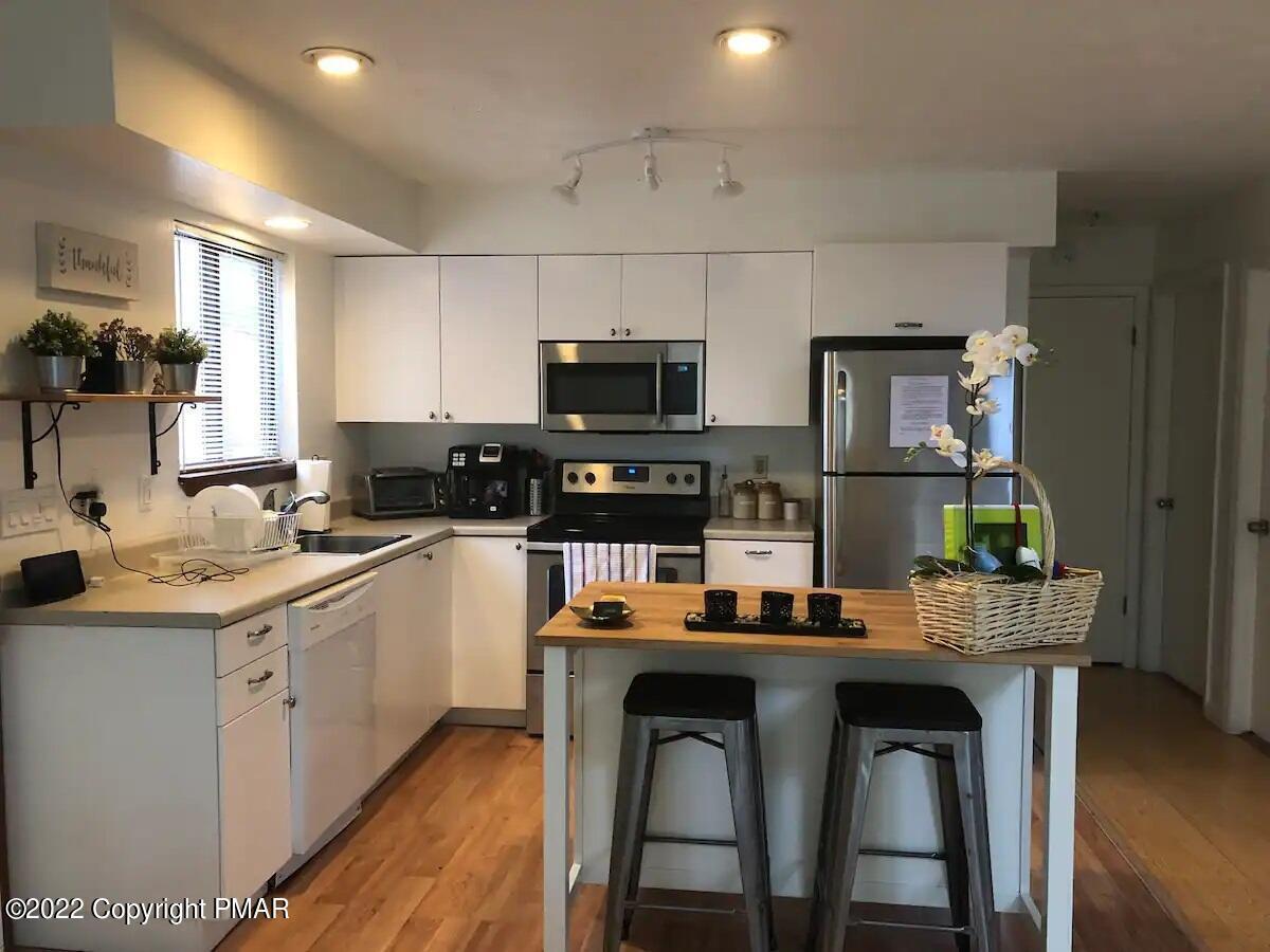 1421 Clover Road Long Pond, PA 18334 - Photo 7 of 31 a kitchen with stainless steel appliances granite countertop a stove top oven a sink dishwasher and white cabinets with wooden floor