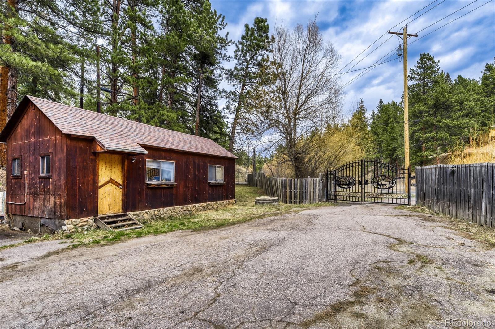 7489 South Turkey Creek Road Morrison, CO 80465 - Photo 3 of 28 a front view of a house with a yard