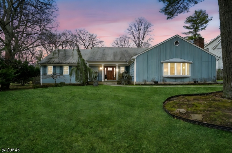 a view of a house with a big yard and large tree