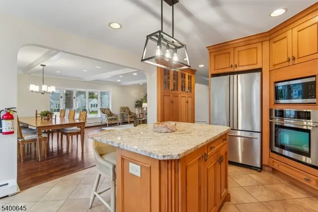 a kitchen with stainless steel appliances granite countertop table chairs and refrigerator