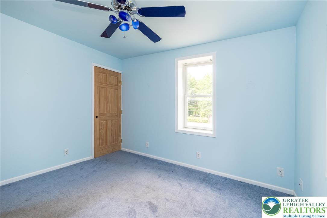 1815 Leithsville Road Hellertown, PA 18055 - Photo 12 of 38 A well-lit bedroom with a ceiling fan for comfort and an outdoor view through the window.