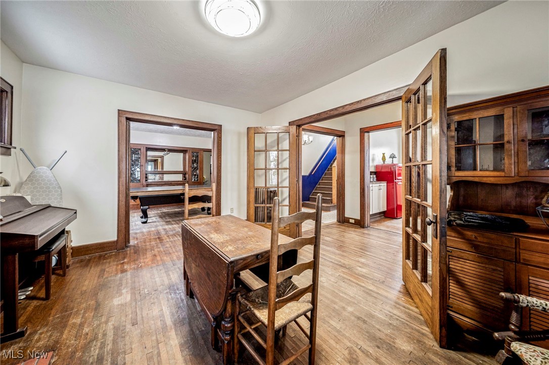 977 West Prospect Road Ashtabula, OH 44004 - Photo 11 of 42 Dining room with french doors, wood-type flooring, a textured ceiling, and stairs